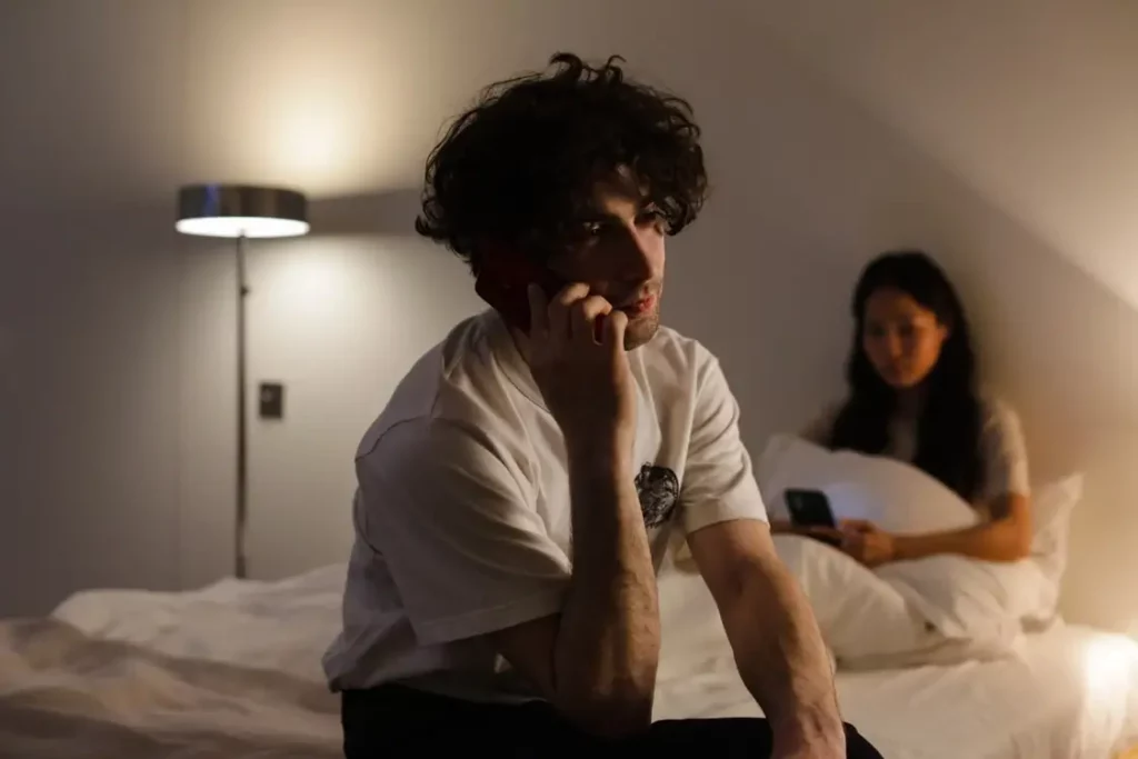 Couple distant dans une chambre, illustrant la détresse relationnelle liée à l'éjaculation précoce — consultation sexologue à Strasbourg